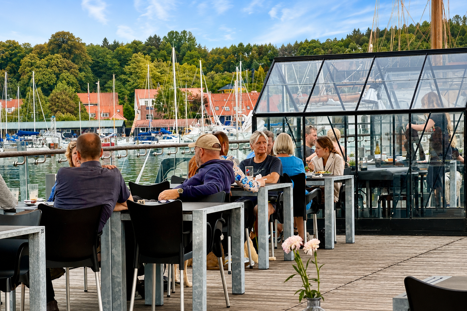 Gæster nyder mad og drikke på Café Salts terrasse ved Mariager Fjord